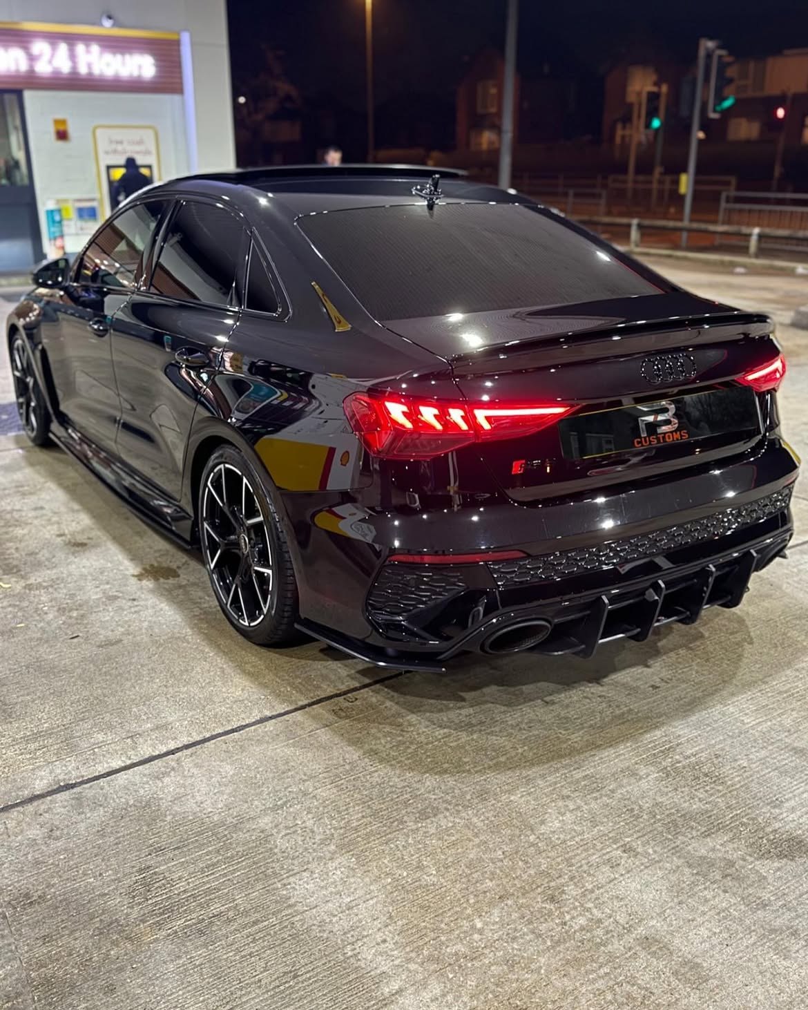 Rear view of a black Audi at night
