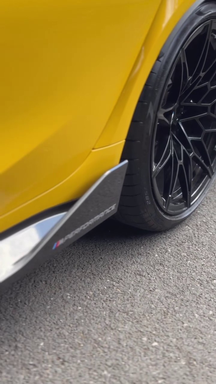 Black wheel and side skirt on a yellow BMW M3