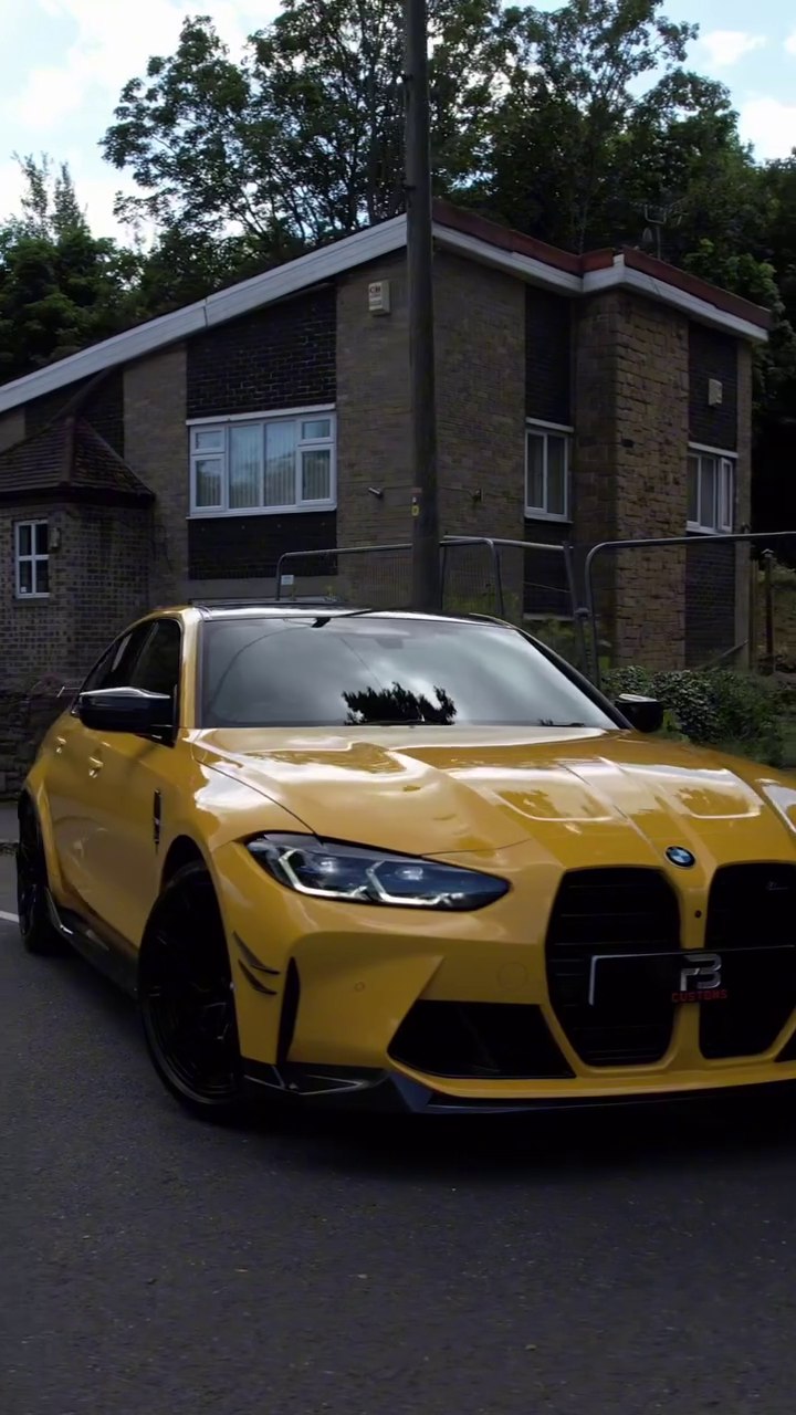 Front angle of a yellow BMW M3 on a road