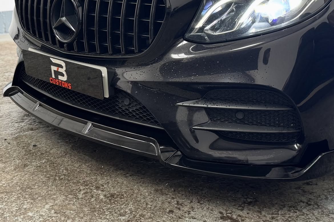 Close view of the fitted front splitter on a black Mercedes